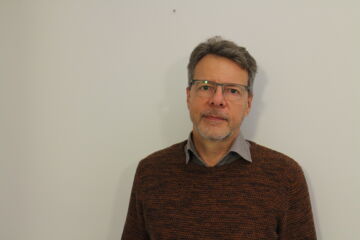 Mies katsoo kameraan